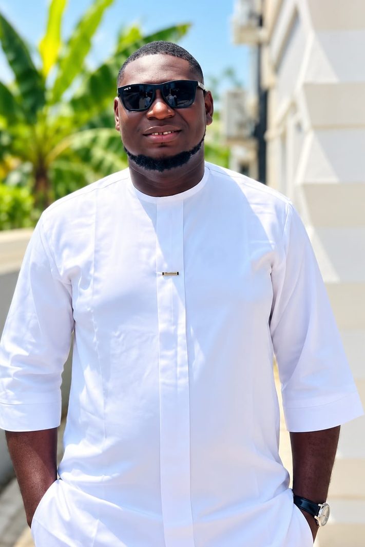 Portrait of Kennedy Aisosa Ogbeifun, Manager and Partner at Green Cycler, in a white tunic and sunglasses